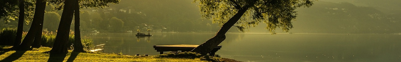 En bord du lac de baignade Weissensee au soleil couchant (Carinthie, Autriche)