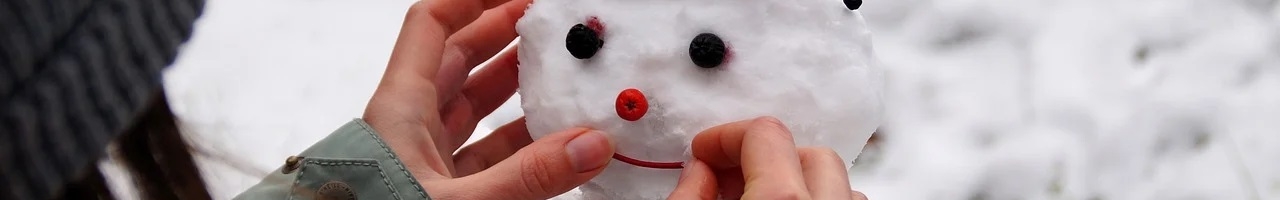 Enfant décorant son bonhomme de neige