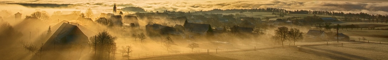 Village dans la brume au soleil levant
